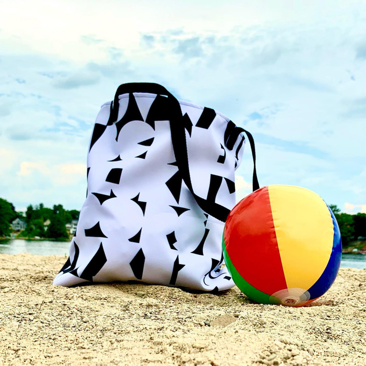 Black and white alphabet tote on beach with beach ball.